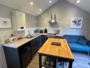 a kitchen with a table and a blue couch at Beautiful self-catering cottages, Ribble Valley in West Bradford