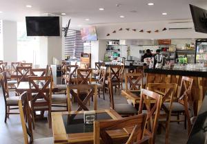a restaurant with wooden chairs and a bar at Hotel ANB Aeropuerto Guadalajara in Guadalajara