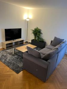 a living room with a couch and a flat screen tv at New&Cosy - Near Disney/Paris - 100m RER A in Lognes