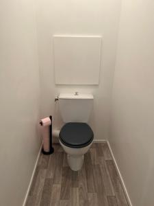 a bathroom with a white toilet with a black seat at New&Cosy - Near Disney/Paris - 100m RER A in Lognes