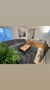 a living room with a couch and a table at New&Cosy - Near Disney/Paris - 100m RER A in Lognes