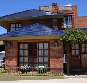 una casa de ladrillo rojo con ventanas y una puerta en Ayres House en Colonia del Sacramento