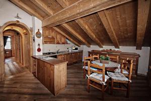 una cucina con tavolo e alcuni armadi in legno di Appartamento Mainardi ad Auronzo di Cadore