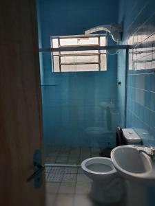 ein blaues Badezimmer mit Toilette und Waschbecken in der Unterkunft Home in Family in Maceió + 10 Fotos