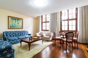 a living room with a blue couch and a table at Hospedaria Santo André in São Paulo +55 photos