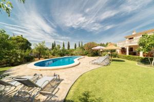 a backyard with a swimming pool and chairs and a house at Estern in Pollença