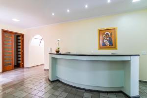 a lobby with a counter with a painting on the wall at Hospedaria Santo André in Sao Paulo
