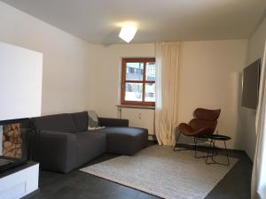 a living room with a couch and a chair at Premium-Chalet Achental mit Kamin und Sauna in Schleching