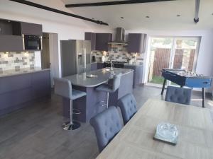 a kitchen with a table and a ping pong table at willow tree farm cottage with BBQ hut in Tattershall Thorpe