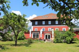 ein großes rotes Haus mit schwarzem Dach in der Unterkunft Hotel-Landgasthof Katschtalerhof in Rennweg