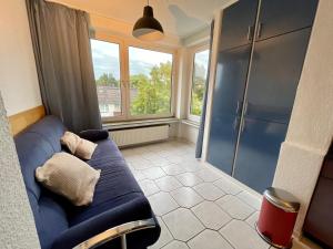 ein Wohnzimmer mit einem blauen Sofa und einem Fenster in der Unterkunft Purple Kitchen - Apartment mit großer Wohnküche in Bremerhaven