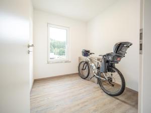 Una bicicleta estacionada en una habitación con ventana en Ferienwohnung Zollhaus, en Saint-Vith