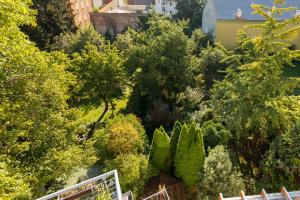een uitzicht over een tuin met bomen en struiken bij Hotel Atlas in České Budějovice