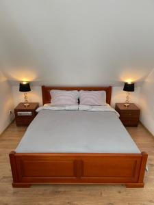 ein Schlafzimmer mit einem großen Bett mit zwei Nachttischen in der Unterkunft Willa Bursztyn in Dębki