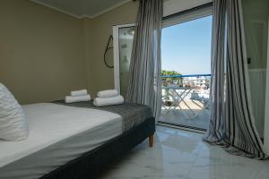 a bedroom with a bed and a view of a balcony at Miracle Luxury Apartments in Perea