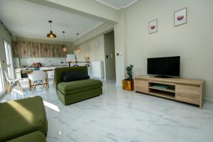 a living room with a green couch and a television at Miracle Luxury Apartments in Perea