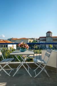 a table with chairs and a vase of flowers on a balcony at Miracle Luxury Apartments in Perea