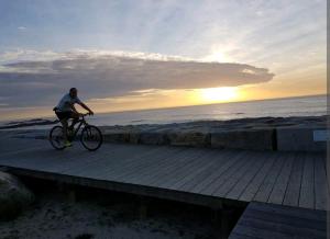a person riding a bike on a boardwalk on the beach at Vivenda junto ao mar in Mindelo