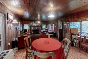 uma sala de jantar com uma mesa vermelha e cadeiras em Pine Cone Cottage em Joseph