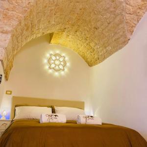 una camera da letto con un grande letto e un soffitto in pietra di Dimora Le Volte Ostuni a Ostuni