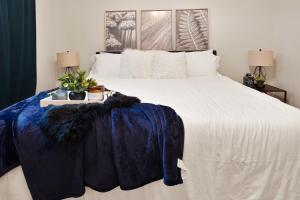 a bedroom with a large white bed with a blue blanket at HOUSTON LINK HOUSE 2bed 2bath TownHouse Enclosed garage Astrodome Downtown MedCtr in Houston