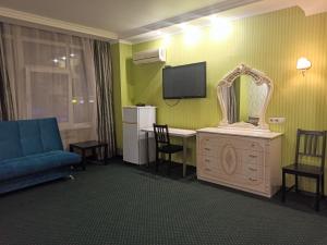 a hotel room with a blue couch and a tv at Express Hotel&Hostel in Kazan