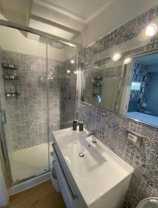 een badkamer met een witte wastafel en een douche bij Domus Gaudens Luxury Apartment in Taormina