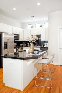 a kitchen with white cabinets and a black counter top at HOUSTON LINK HOUSE 2bed 2bath TownHouse Enclosed garage Astrodome Downtown MedCtr in Houston