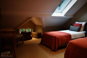 a attic bedroom with a bed and a window at La Villa du Pré Du Cerf---------- TARIF PREFERENTIEL 2 NUITS------- in Spa