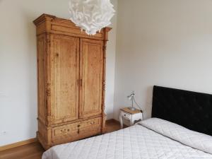 een slaapkamer met een houten kast naast een bed bij San Francesco in Lucca