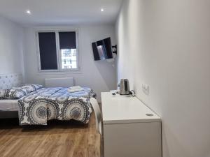 um pequeno quarto com uma cama e uma mesa em Nanterre Room em Nanterre