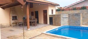 een zwembad in de achtertuin van een huis bij Incrivel casa a 280 m do mar em Peruibe SP in Peruíbe