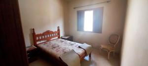 een slaapkamer met een bed, een raam en een stoel bij Incrivel casa a 280 m do mar em Peruibe SP in Peruíbe