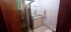 een badkamer met een wastafel, een toilet en een spiegel bij Incrivel casa a 280 m do mar em Peruibe SP in Peruíbe +14 foto's