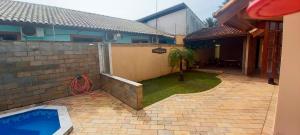 een achtertuin met een zwembad en een huis bij Incrivel casa a 280 m do mar em Peruibe SP in Peruíbe