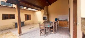 een keuken met een tafel en stoelen in een kamer bij Incrivel casa a 280 m do mar em Peruibe SP in Peruíbe