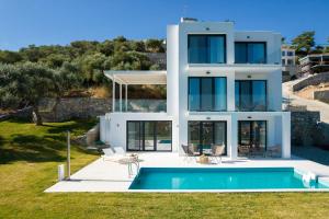 une maison avec une piscine en face de celle-ci dans l'établissement Hillside Villa - Thea, à Thasos