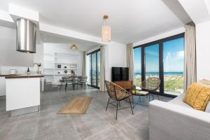 a living room with a couch and a table with chairs at Hillside Villa - Thea in Limenas