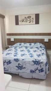 a bed with a blue and white comforter on it at Lacqua Diroma Caldas Novas PB Turismo in Caldas Novas