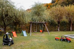 a playground with toy cars and a swing set at Casa Ardeleana in Lotrioara