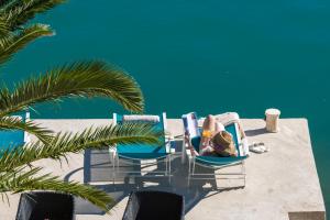 una ragazza che giace su un patio con sedie di Adria House Dubrovnik by the sea a Zaton