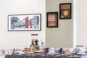 a table with food on it with pictures on the wall at Hospedaria Santo André in São Paulo