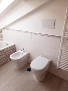 a white bathroom with a toilet and a sink at Cava Resort Costa d'Amalfi in San Pietro