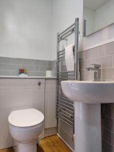 uma casa de banho com um WC branco e um lavatório. em Hartfell Guest House em Moffat
