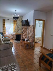 ein Wohnzimmer mit einem Sofa und einem Kamin in der Unterkunft Alojamiento valeria in Arroyo Frio