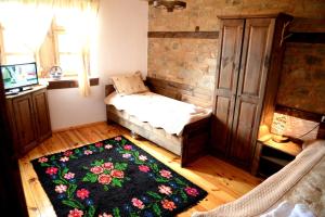 a room with a bed and a rug on the floor at Guest House Pri Malkiya in Leshten