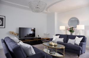 a living room with a blue couch and a table at Lorna House Totnes in Totnes