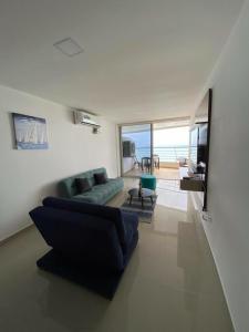 a living room with a blue couch and a view of the ocean at Departamento frente al mar, FONTAINE BLEAU in Tonsupa