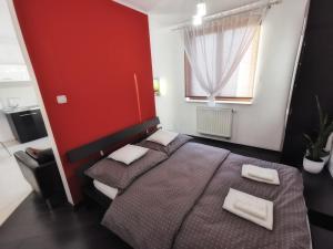 1 dormitorio con 2 camas y pared roja en Apartament 33, en Cracovia