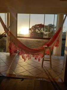 a hammock in a room with a window at Caiowa Floripa guesthouse in Florianópolis